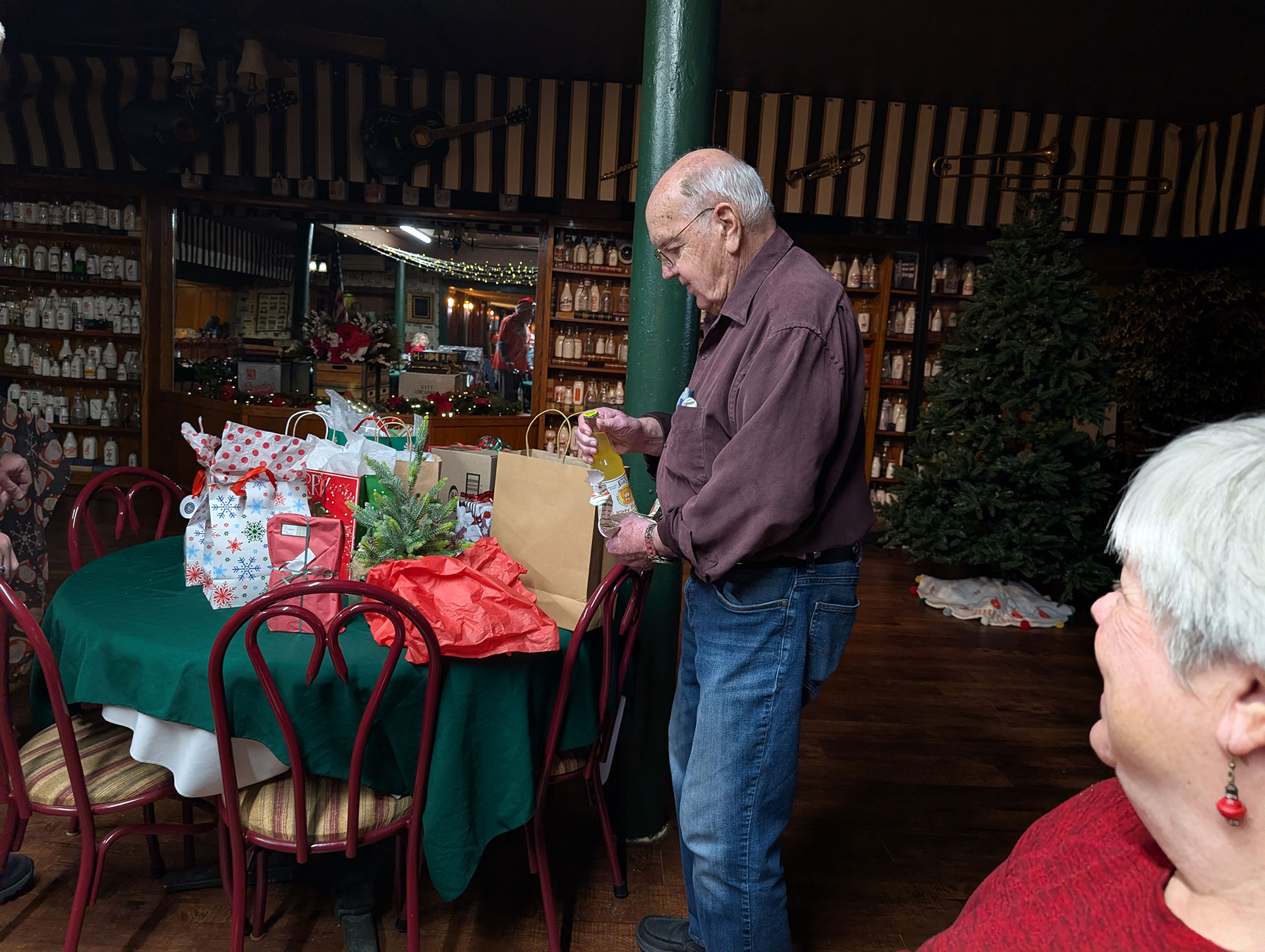 Image of Dean Bauer opening his first gift which was a bottle of joke soda | Kiwanis Club of Bradford