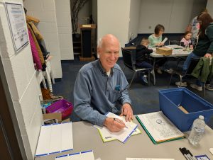Image of Dr. Dick Dryden greeting guests as they come in and directing them to the craft stations Kiwanis Kraft Days | Kiwanis Club of Bradford